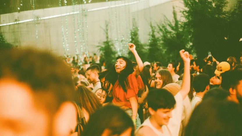 juwenalia warszawa 2025 - tłum studentów na koncercie podczas wieczornego festiwalu muzycznego z widocznymi flagami uczelni warszawskich