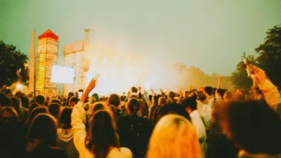 Studenci świętujący podczas koncertu Juwenalia Kielce 2025 w Amfiteatrze Kadzielnia z kolorowymi światłami scenicznymi.
