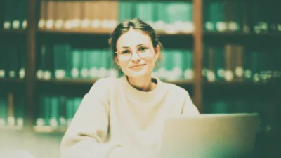 Wstęp do pracy magisterskiej - studentka pisząca wstęp do pracy przy biurku z notatkami i laptopem