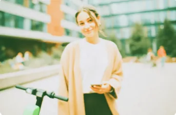 Lime kod promocyjny - studentka pokazująca na telefonie aplikację Lime z kodem rabatowym przy hulajnodze elektrycznej