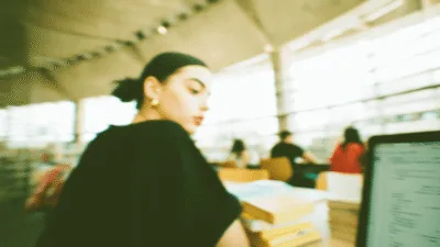 Koreanistyka - studentka ucząca się języka koreańskiego w bibliotece uniwersyteckiej z materiałami do nauki