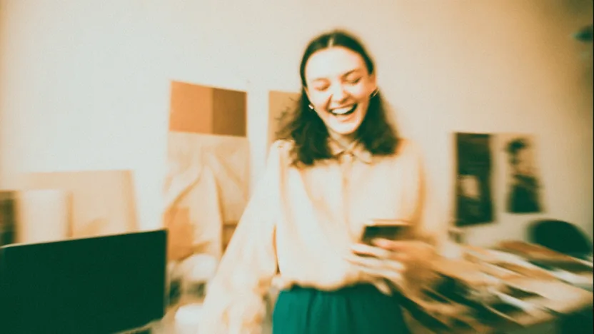 Wyniki matur 2025 - studentka sprawdzająca wyniki egzaminu maturalnego na telefonie