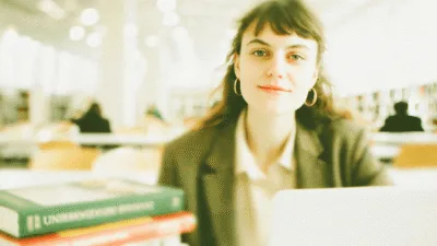 Studia psychologiczne - studentka czytająca podręczniki z psychologii w bibliotece uniwersyteckiej