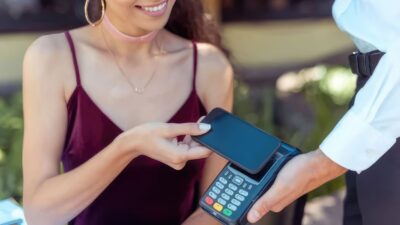 Studentka płaci telefonem w kawiarni za granicą — konto studenckie i karta wielowalutowa