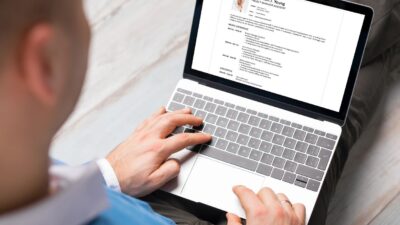 Jak napisać CV bez doświadczenia, student piszący pierwsze CV na laptopie